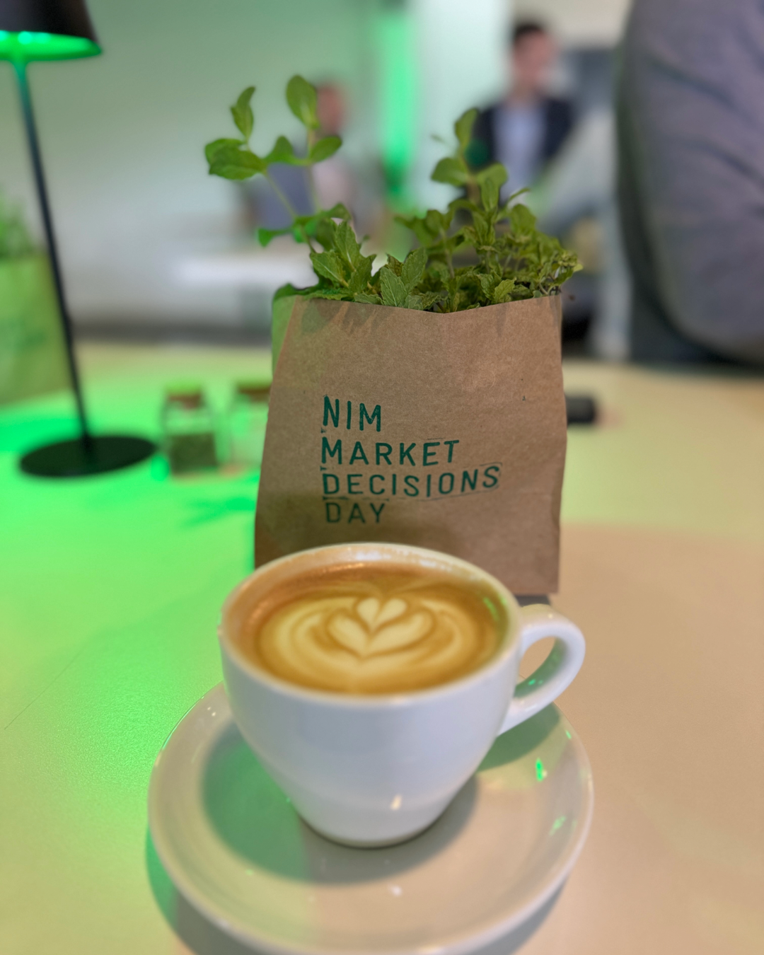 apmBlog_NIM_MarketDecisionsDay2026_Kaffee_und_Kräutertopf Cappucino und ein Kräutertopf beim NIM Market Decisions Day